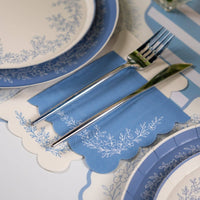 Blue floral guest towels styled with matching plates and blue napkins on table.
