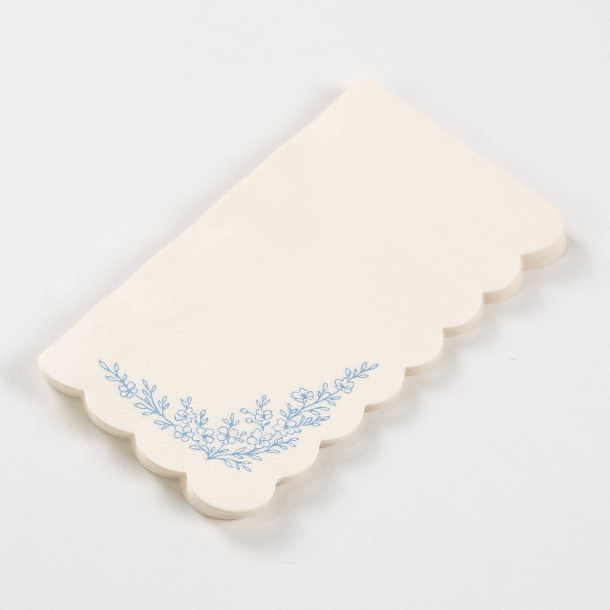 Stacked blue floral guest towels with scalloped edges and floral print.
