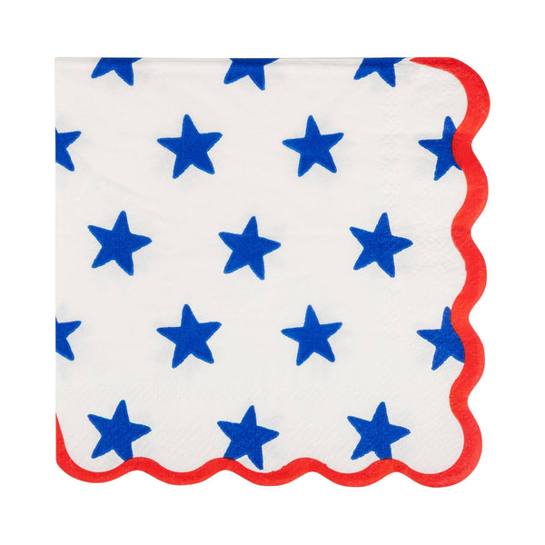 Blue star print scalloped paper cocktail napkin on cream background with red scalloped edge
