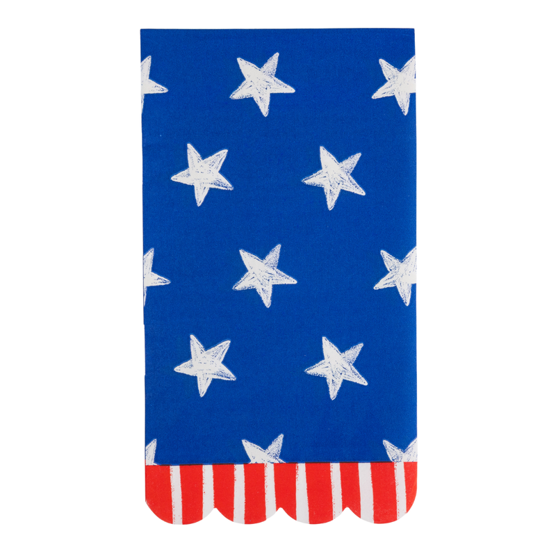 Single blue star scalloped paper guest towel napkin laid flat showing cream hand-sketched stars on a blue background with red and cream striped scalloped border along the bottom edge