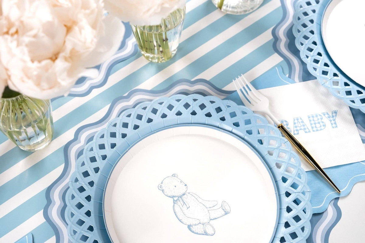 Blue teddy bear dessert plate on a blue and white striped table with peonies in glass vases