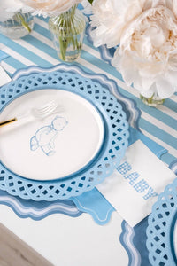 Blue teddy bear paper plate on a blue striped runner with white peonies and a gold handled fork