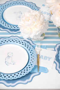 Two blue teddy bear paper plate settings with gold flatware, peonies, and blue gingham napkins