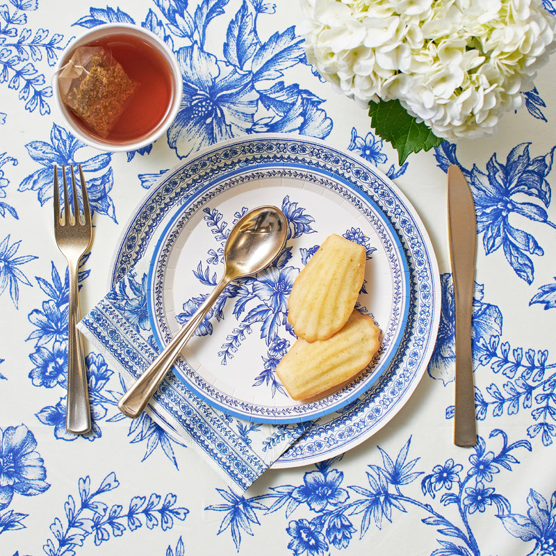 Blue toile napkins styled with tea, pastries, and place setting