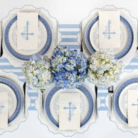 An angled close up of a white guest towel featuring a light blue cross and Heirloom Watercolor floral sprigs.