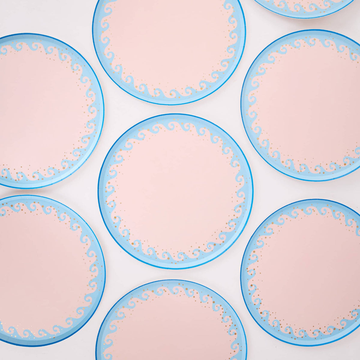 Repeating pattern of blue wave dinner plates showing the wave scroll border and gold foil detail.