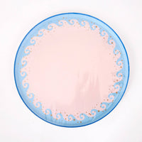 Single blue wave scalloped paper dinner plate with a blush center, light-blue wave border, and gold foil dots.