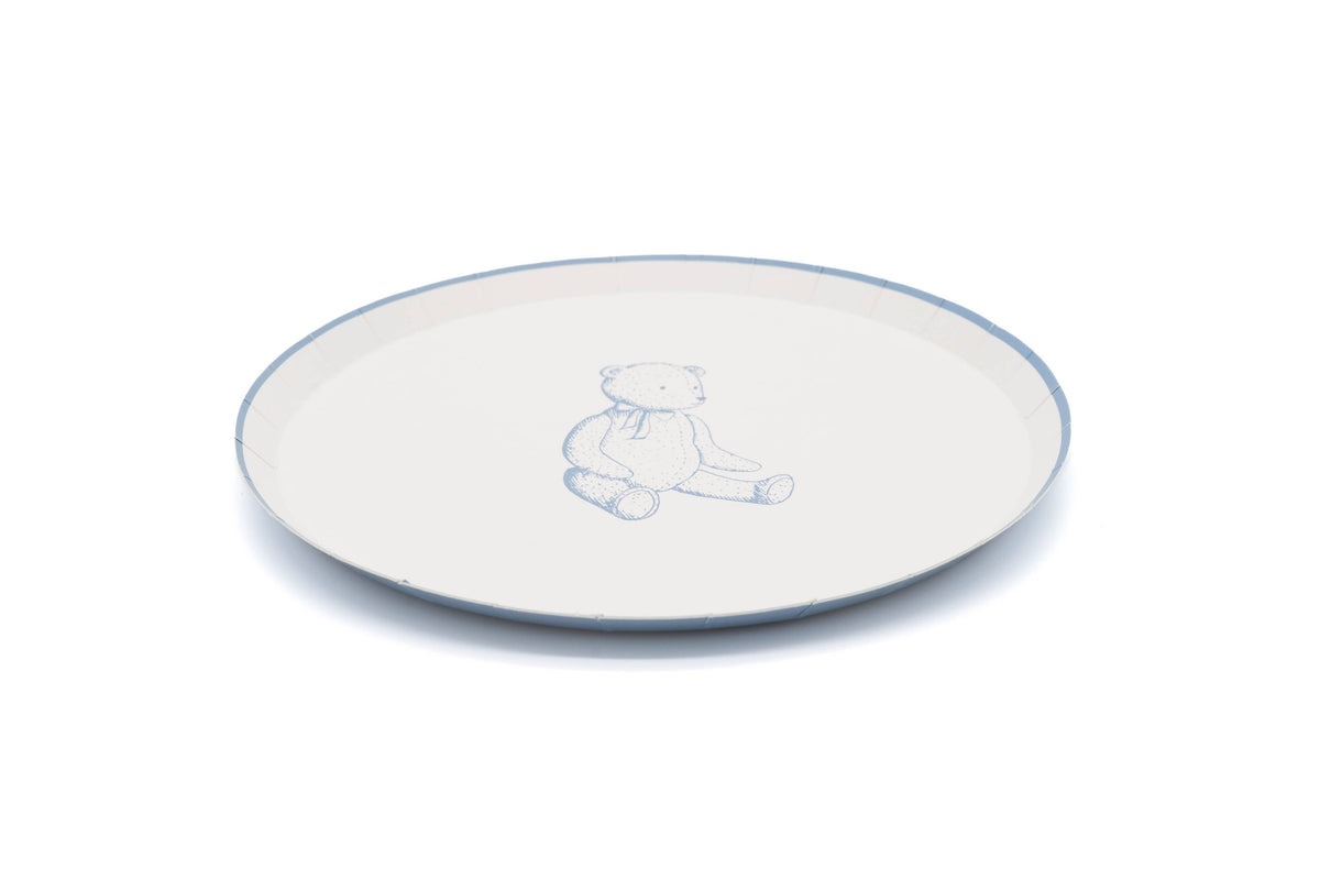 Edge of a cream teddy bear paper plate with a thin blue rim and the bear print in soft blue