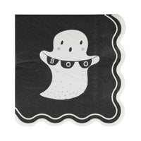 Unfolded black cocktail napkin with white ghost holding “BOO” banner and scalloped white edge