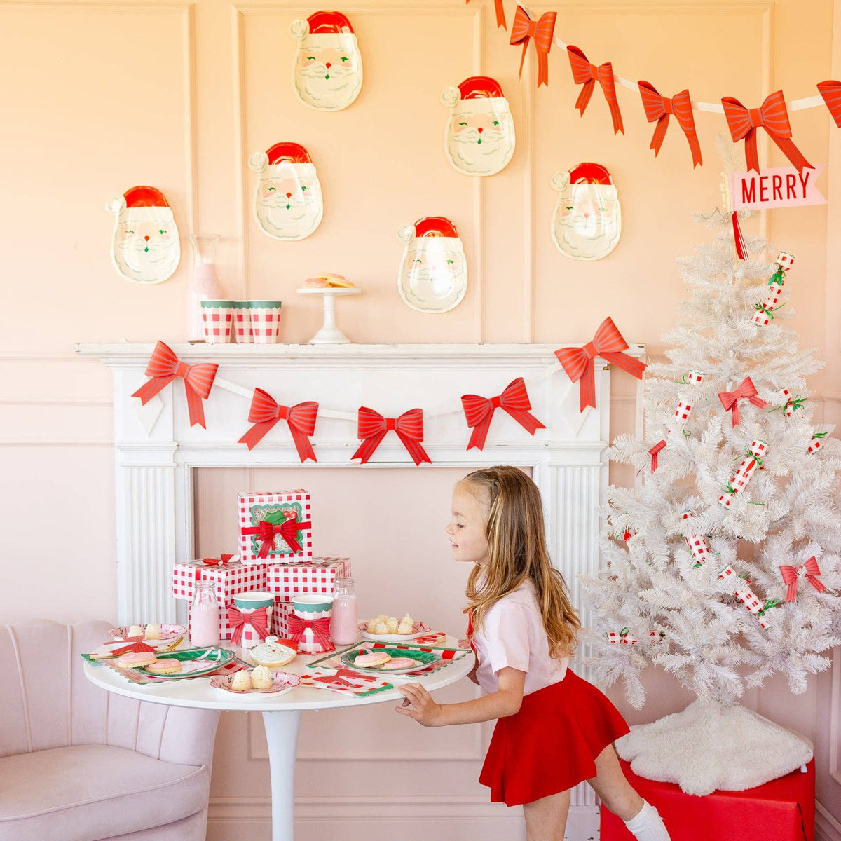 Full holiday setup featuring red bow banner, white tree, and Santa plates