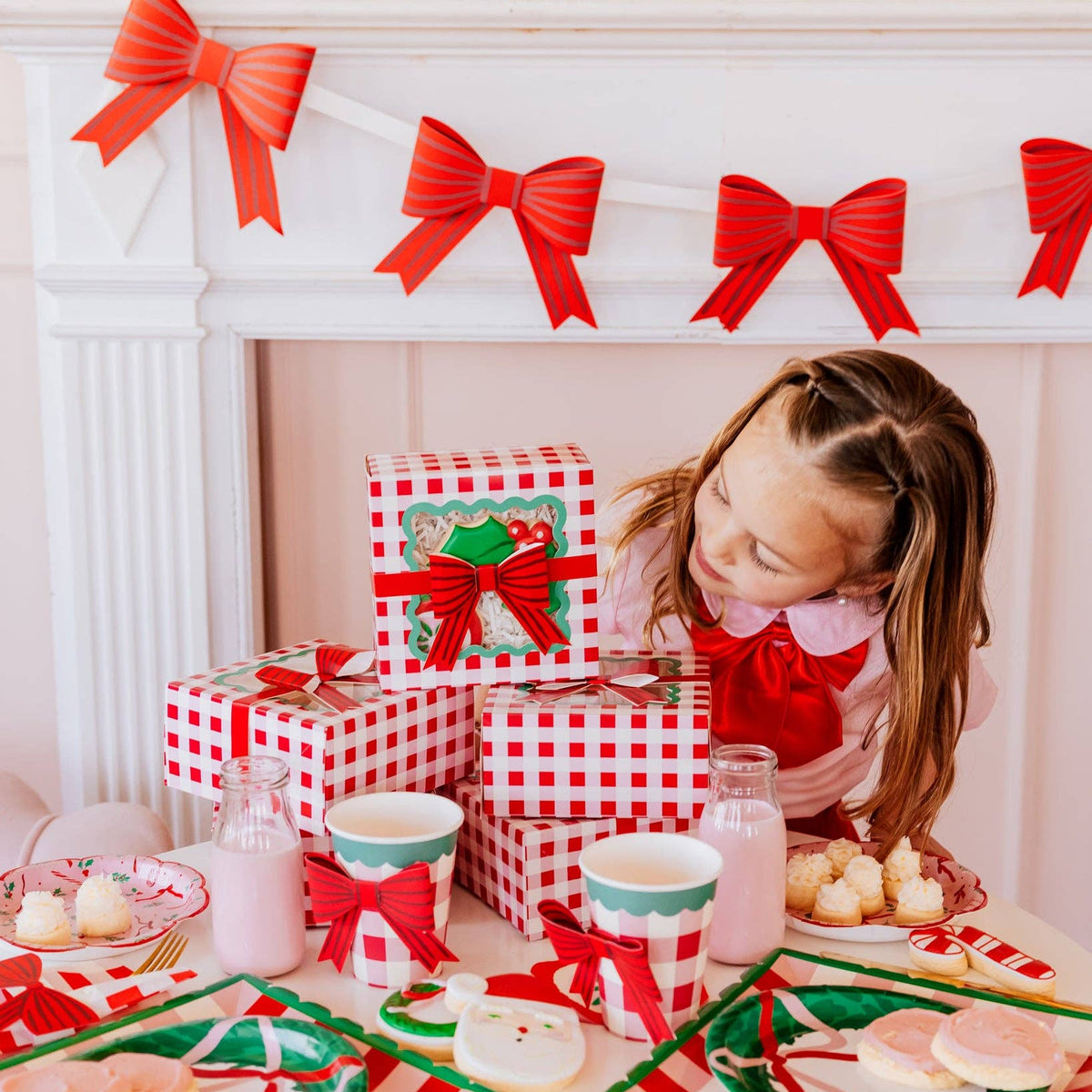 Girl enjoying Christmas treats beside red bow decorations