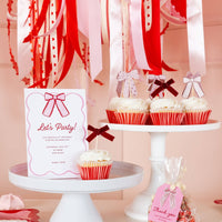 Bow cupcake toppers displayed on frosted cupcakes on dessert stands