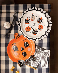 Bow napkin at a place setting on a vintage black-and-cream Halloween table.