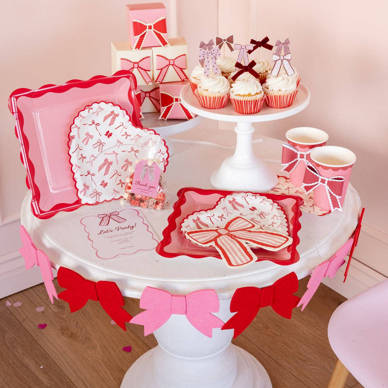 Valentine table setup featuring bow pattern napkins and party decor