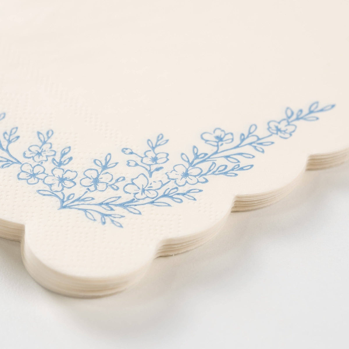Close-up of dusty blue guest towel showing floral corner detail.
