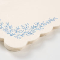 Close-up of dusty blue guest towel showing floral corner detail.
