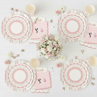 Overhead view of four party place settings with pink bow cups and flowers
