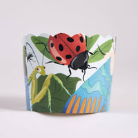 Single bug-and-leaf illustrated cupcake baking cup with a ladybug