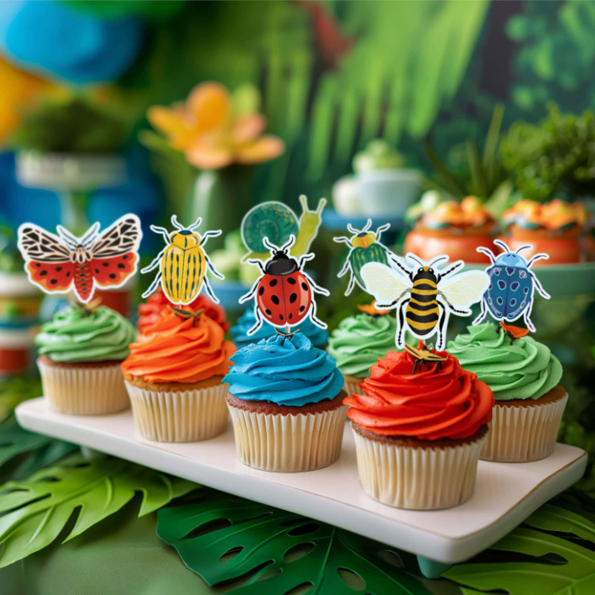 Bug topper cupcakes on a tray against a green garden backdrop