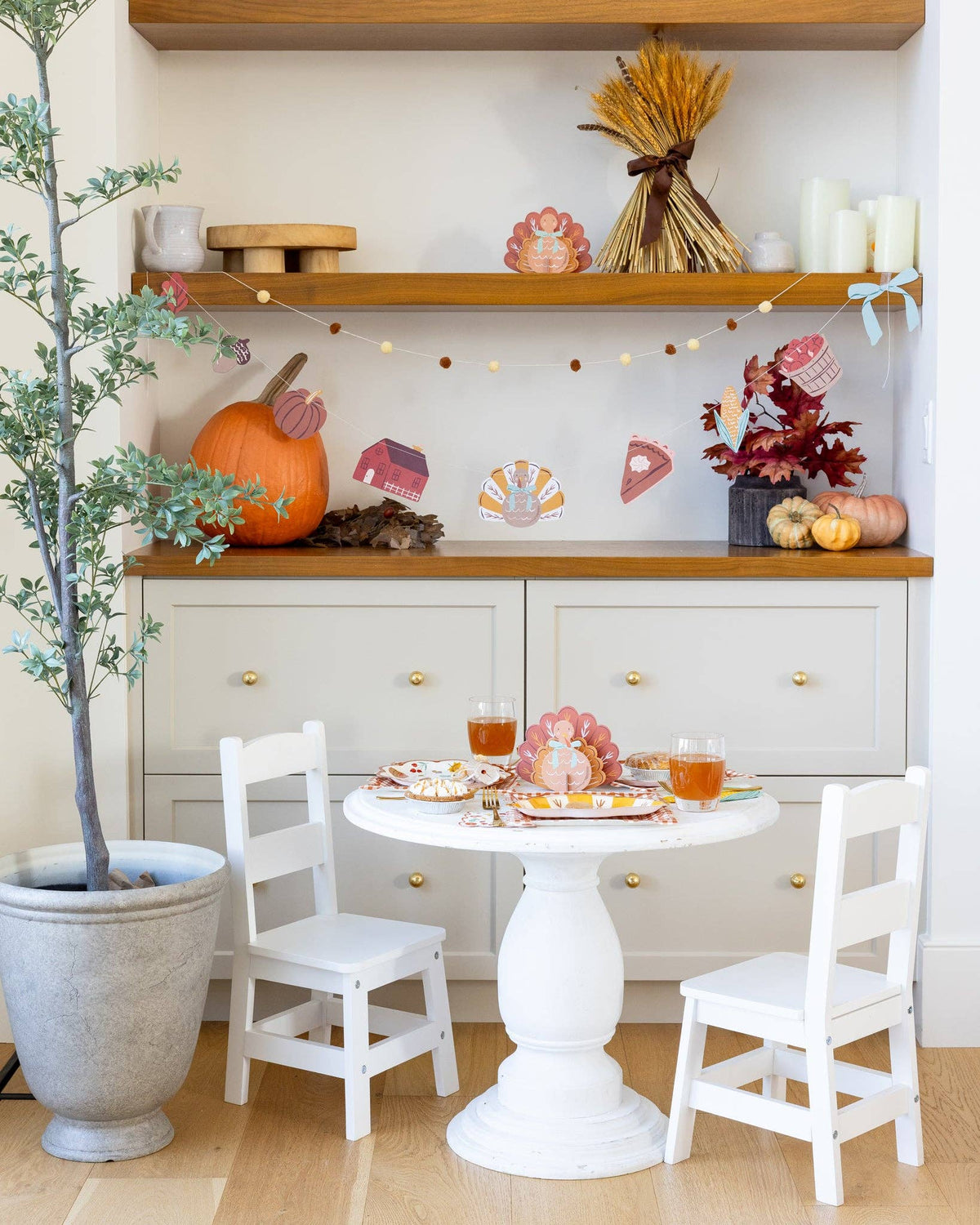Dining area with a small table and chairs, featuring a completed turkey centerpiece for a fall theme.