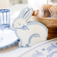 Bunny shaped napkins displayed on an Easter table with blue plates and spring décor