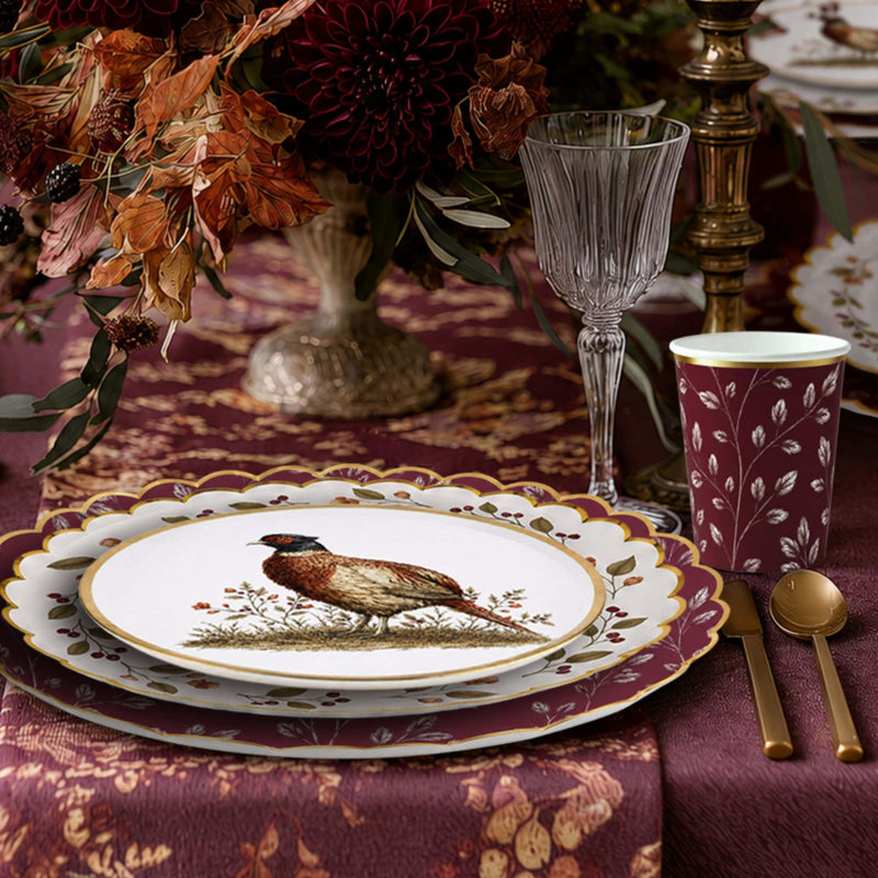 Burgundy leaf cup beside a candlelit place setting with gold flatware and a crystal wine glass