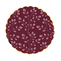 Burgundy dinner plate with an allover etched white leaf print and gold scalloped rim on a white background