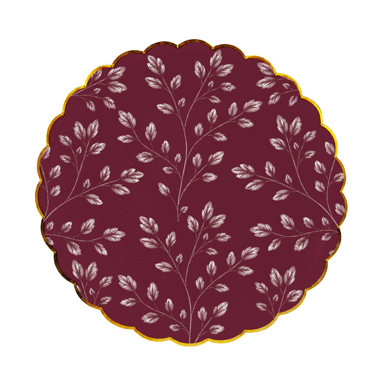 Burgundy dinner plate with an allover etched white leaf print and gold scalloped rim on a white background