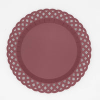 Deep burgundy dinner plate with an embossed basketweave texture and a lattice cutout scalloped border, overhead view on white background.