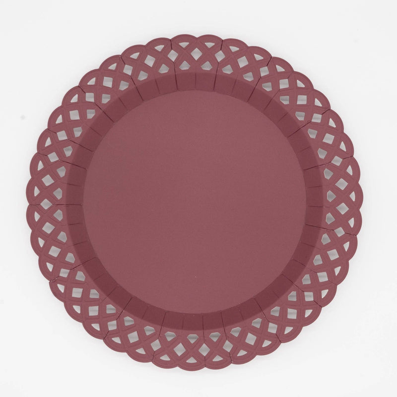 Deep burgundy dinner plate with an embossed basketweave texture and a lattice cutout scalloped border, overhead view on white background.