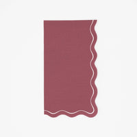 Solid burgundy fall guest towel in deep wine with a wavy scalloped cream-outlined edge, flat view on white background.