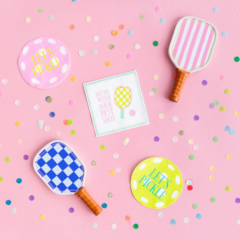 Pink backdrop with confetti, round ‘Let’s Pickle’ coasters, square pickleball napkin saying ‘Hit Me With Your Best Shot’, and paddle‑shaped plates.