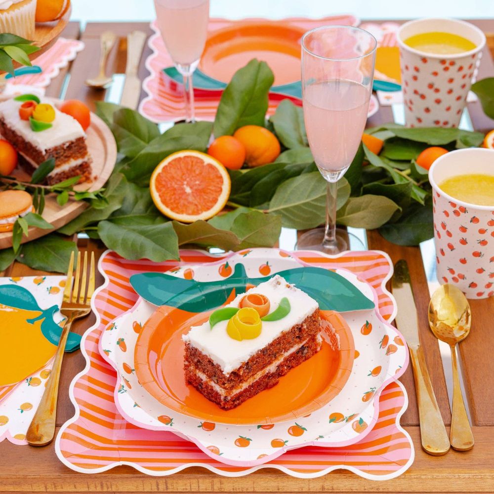 Slice of cake served on orange and pink striped party plate.
