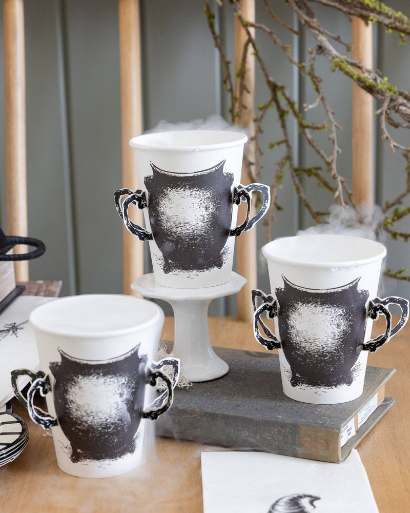 Cauldron paper cups styled on a Halloween table.