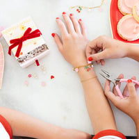 Kids assembling charm bracelets using a Charm Bracelet Kit during a Valentine craft activity.