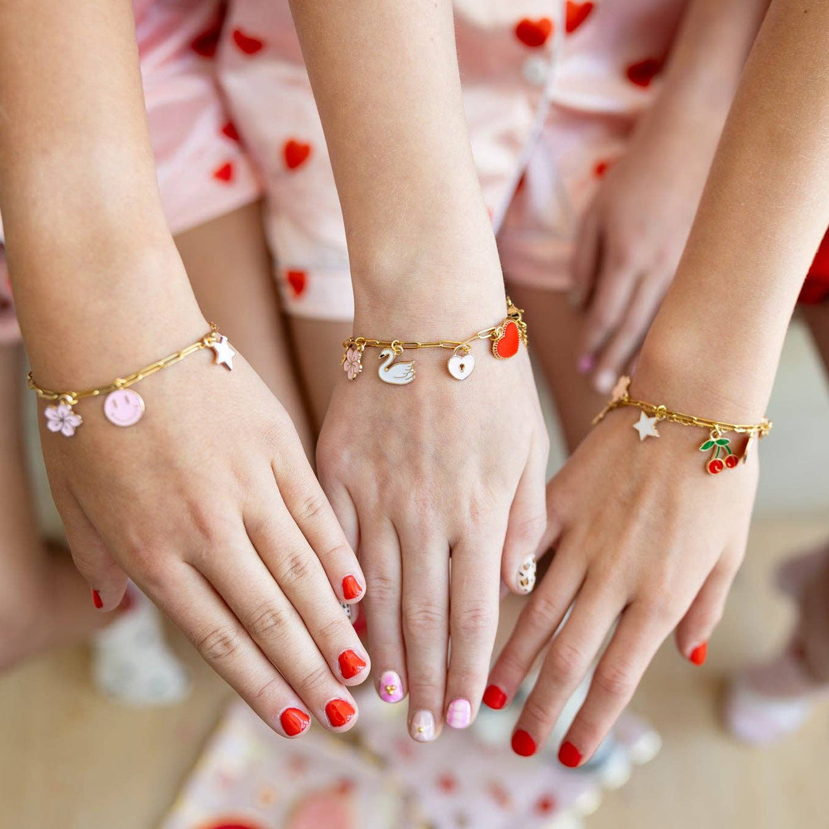 Kids wearing Valentine-themed charm bracelets created with a Charm Bracelet Kit.