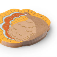 Stack of gold-accent turkey shaped napkins in warm autumn colors, angled close-up.