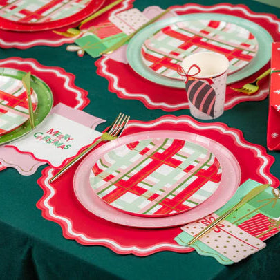 Holiday table runner with dotted dinner plates and plaid dessert plates—easy Christmas party supplies mix.