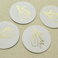 Set of four round Cocktail Coasters with champagne bottle and cheers design—ideal for engagement supplies party.