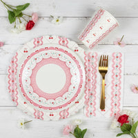Full table setting with cherry cups, stacked plates, and gold flatware