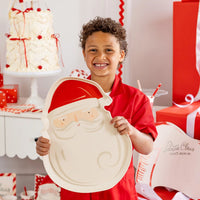 Young child smiling while holding the large, reusable Santa tray in a Christmas party setting.