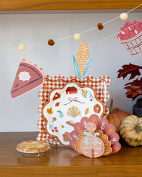 Decorative Thanksgiving scene with a finished assembled chipboard turkey standing upright, a pie, and some autumn themed decorations on a wooden table.