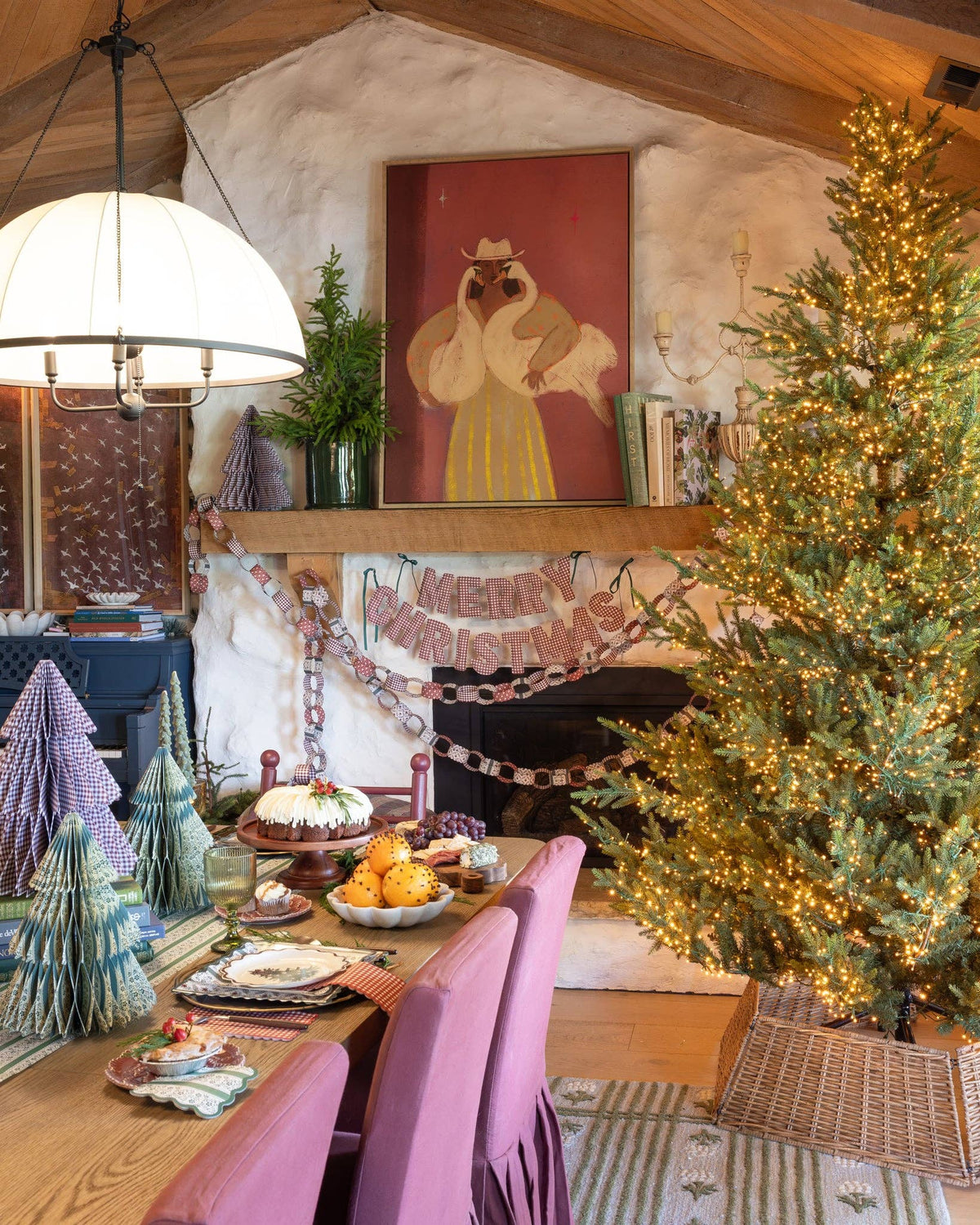 Christmas dining room with gingham banner over fireplace, paper trees, and holiday table