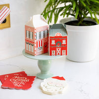 Merry Christmas napkins displayed with Santa plates and North Pole treat boxes