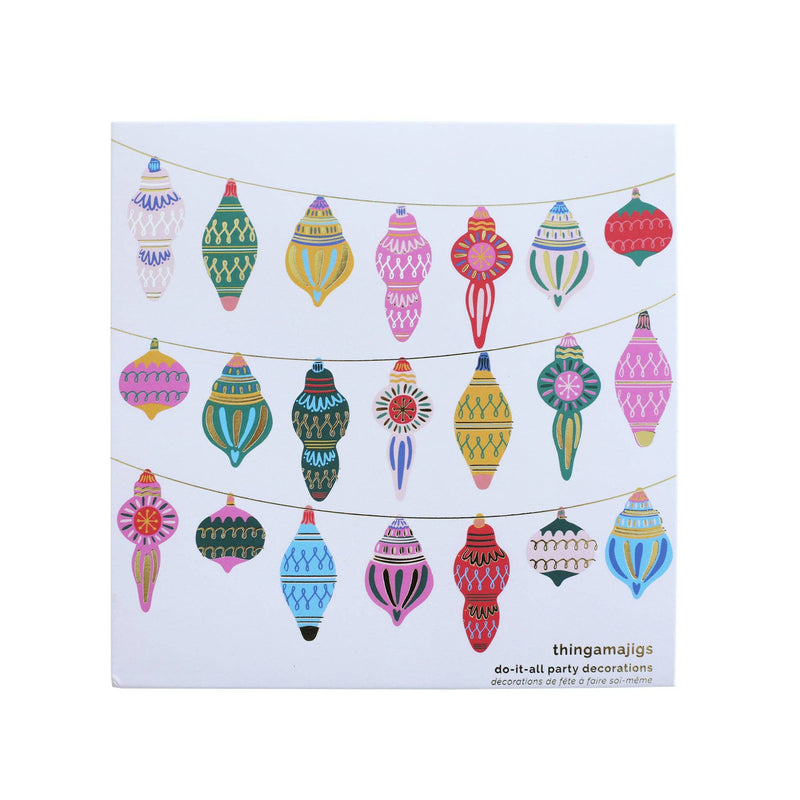Christmas ornament garland of colorful die-cut vintage ornaments in reds, greens, blues, pinks, and gold strung on twine, front view on white background.