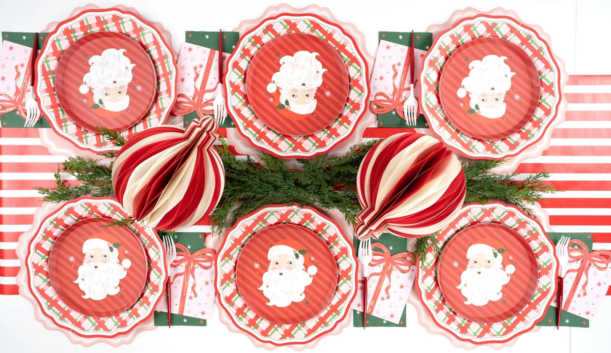 Overhead with striped ornaments, Santa plates, red doily chargers, and green star guest towels.