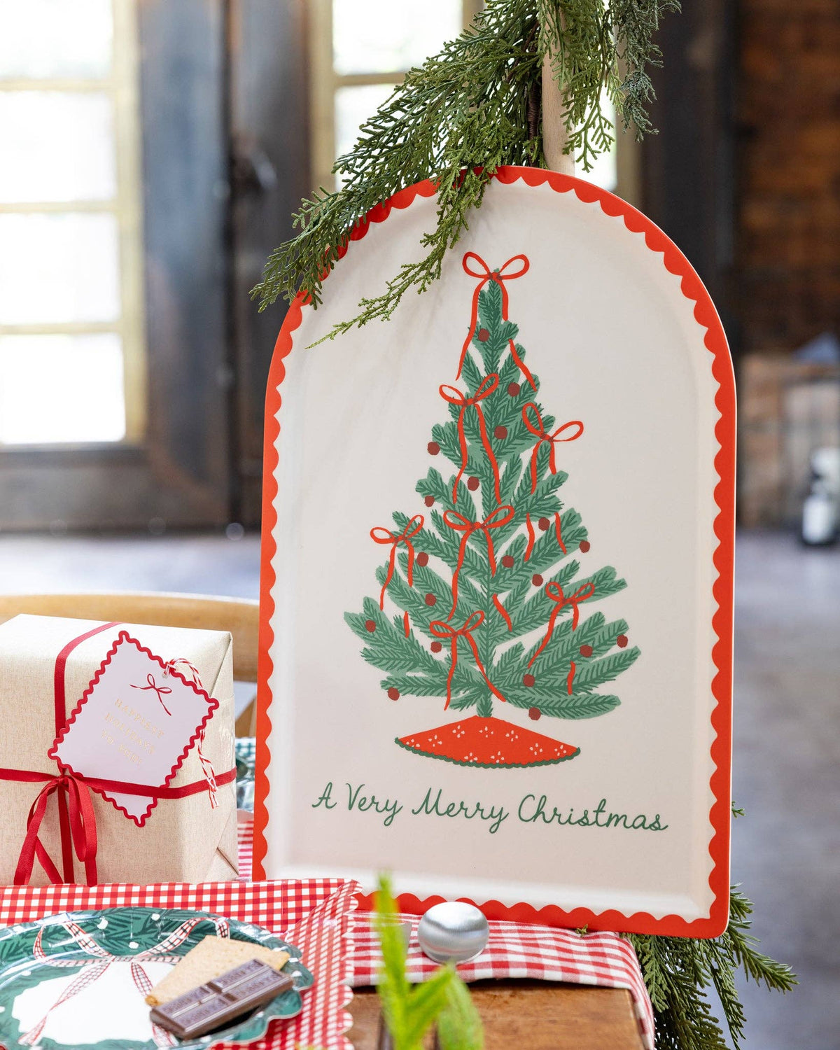 The bamboo tray propped on a rustic console with a Christmas tree and greenery.
