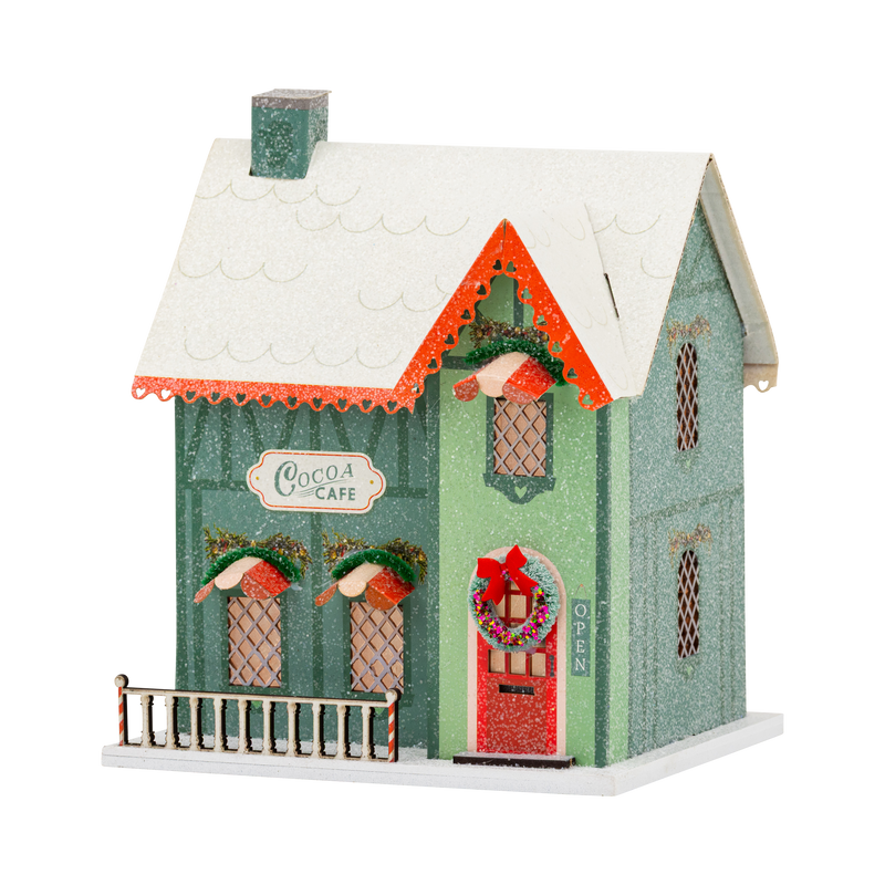 Green glitter cocoa cafe putz house with snowy roof, red door wreath, and candy striped porch rail