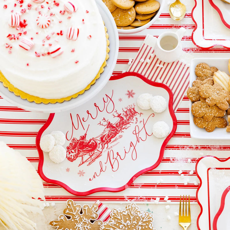 Overhead shot of the Christmas tray platter covered in cookies and powdered sweets next to a white cake.