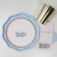 Close-up of the gold foil plates and matching pink napkin, styled next to a gold cup and white flowers.